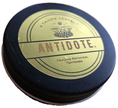 Antidote tallow balm in a black tin with gold label